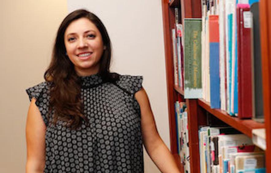 This is a picture of Natalia in front of a bookshelf